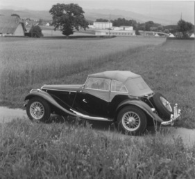 MG Midget Series TF (1954) - geschlossenes Dach und Fenster, von schräg hinten gesehen