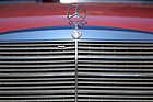 Mercedes Benz 200 (1982) - für die Entriegelung der Motorhaube ist der kleine Plastikgriff links unter dem Stern zuständig