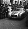 Image: Mercedes Benz 300 SL (1952) - Rudolf Caracciola, in fourth position at the Mille Miglia in May 1952, is kept at a distance from his fans by police officers in parade uniform in the cities