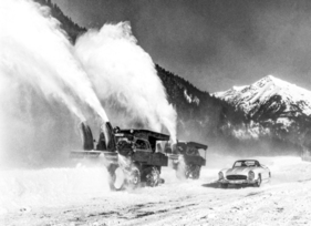 Bild Mercedes-Benz 300 SL Roadster (1960) - zeitgenössische Genreaufnahme in den verschneiten Bergen und mit Schneefräsen auf der Basis von Mercedes-Benz Unimog