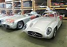 Das "rote" Coupé im Lager der Mercedes-Benz-Sammlung. Neben ihm steht eines der nie eingesetzten 1956er Modelle, erkennbar an der Motorhaube, mit der Startnummer von Fangios 1955er Mille-Miglia-Wagen.