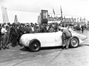 Mercedes-Benz SSKL Stromlinie (1932) – Avusrennen 1932: Von Brauchitsch lässt sich in das türlose Cockpit helfen, während zahlreiche Schaulustige die "Gurke" bestaunen