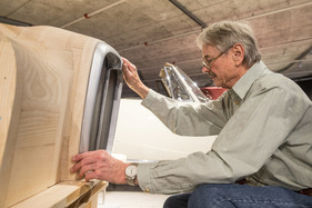 Mit kritischem Blick wird die Passform geprüft - Holzmodell eines Alvis TF 21, hergestellt von Werner Haas für die Sonderschau "Meisterwerke des Hermann Graber" im Pantheon Basel