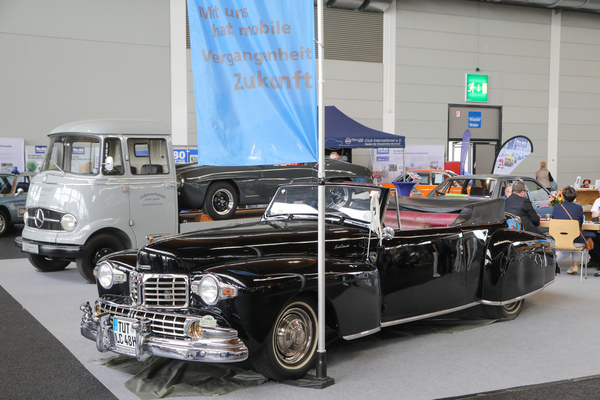 Mit uns hat mobile Vergangenheit Zukunft, steht auf dem Plakat neben dem Lincoln Continental - Klassikwelt Bodensee 2023