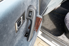 Mitsubishi Debonair (1988) - Schalter für die elektrische Längsverstellung der hinteren Sitzbank neben dem Türgriff