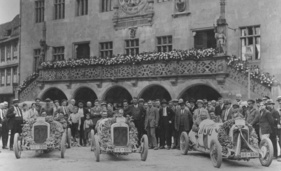 After the quadruple victory in the 1926 German Grand Prix on the AVUS circuit in Berlin, the racing team is welcomed and cheered by the local population in front of Heilbronn town hall.