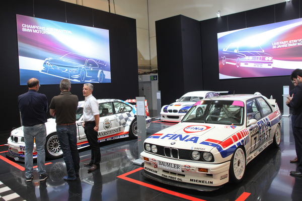 Neuere Rennwagen der Dreierreihe auf dem BMW-Stand, im Vordergrund der berühmte BMW M3 E30 - Techno Classica 2015