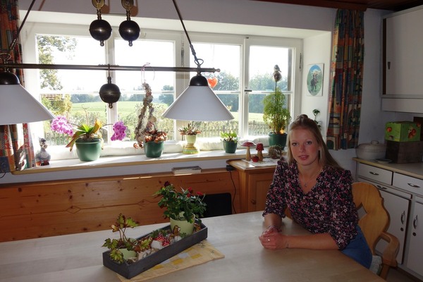 Nina Müller beim Gespräch in der gemütlichen Stube mit Blick auf den Garten und die Alpen