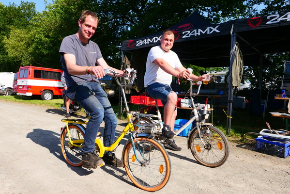 Ökologische Fortbewegungsmittel, ideal für das weitläufige Gelände: Klappräder. Der Herr rechts trinkt sein Dosenbier zum Ausgleich weniger ökologisch aus dem Plastikbecher. – Bockhorner Oldtimermarkt 2025