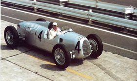 Paul Pietsch, Ex-Rennfahrer und Gründer des Motorpresse Verlags, präsentiert den wiederaufgebauten Auto Union Typ C des Deutschen Musuems am 16.08.1980 beim Oldtimer GP auf dem Nürburgring