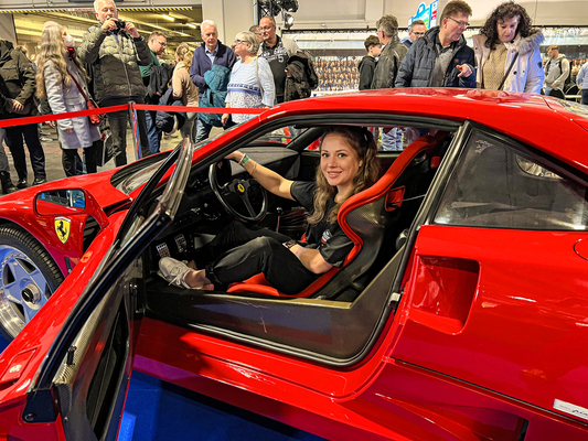 Platz genommen: Smilla Blaube gönnt sich eine kurze Auszeit vom Messetrubel im F40-Fahrersitz – und wird dabei umso mehr von wissbegierigen Besuchern umlagert.