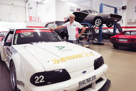 Podcast "Alte Schule" Folge 18 mit Peter Mücke - Peter Mücke posiert vor einem Auto in seiner Werkstatt Podcast "Alte Schule" Folge 18 mit Peter Mücke - Peter Mücke posiert vor einem Auto in seiner Werkstatt