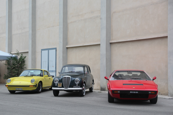 Porsche 911, Lancia und Dino 308 GT4 vor einer Halle - Auto e Moto d'Epoca 2014