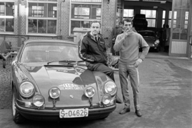 Porsche 911 T Rallye (1968) – Abfahrt zur Rallye Monte Carlo – David Stone sitzt auf dem Coupé, Vic Elford steht daneben. (1968)