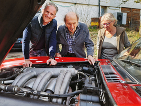Ralph Grieser (links), Heinrich Zollinger (Mitte) und dessen Ehefrau begutachten den imposanten Reihensechszylinder des 300 SL Ralph Grieser (links), Heinrich Zollinger (Mitte) und dessen Ehefrau begutachten den imposanten Reihensechszylinder des 300 SL