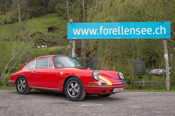 Image: Red Porsche 911 in front of a blue trout lake sign - Herbert Müller Memorial Day and Memorial Rally 2021