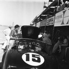 Shelby Cobra Roadster (1963) - Phil Hill (rechts im weissen Helm) inspiziert den Motor seines Shelby Cobra Roadsters (12 Stunden von Sebring 1963)