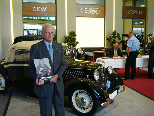 Bild Stolz präsentiert der Sohn das Buch über seinen Vater, im Hintergrund signiert Co-Auto Kirchberg bereits die ersten Exemplare im alten Audi Werk in Zwickau - aus dem Buch "DKW Hahn"