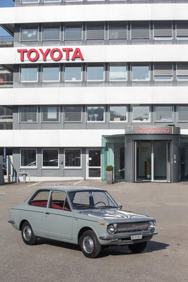 Toyota Corolla 1100 (1968) - die zweitürige Limousine vor dem Gebäude des Schweizer Importeurs Emil Frey AG