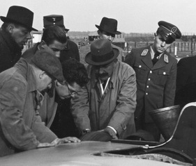 Uhlenhaut und Dietrich untersuchen den Reifen am Rekordwagen Mercedes-Benz W 25 von 1936