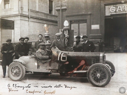 Bild: Von Giuseppe Campari handsignierte original s:w Aufnahme, Enzo Ferrari mit Giuseppe Campari und Attilio Marinoni vor der Garage Gatti (1928) – Automobilia-Auktion Ladenburg 2026