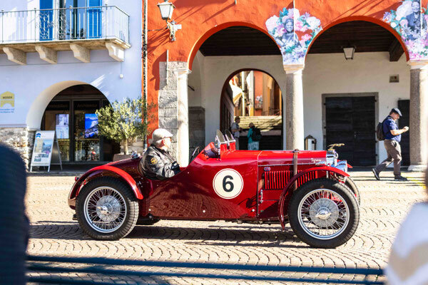 Image: A pre-war two-seater sports car with start number 6 rolls through the streets of Ascona—with wire-spoke wheels and cycloid fenders