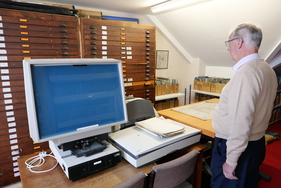 Weitere Schubladen mit Zeichnungen. Die roten Punkte verraten, dass der Inhalt bereits digitalisiert worden ist. Links im Bild ein dafür genutzter Scanner