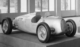 Wellige Motorhaube, ungleiche Länge der Auspuffrohre, welliges, leicht beschädigtes Seitenteil, insgesamt wenig Finish am Auto Union Typ C bei der Eröffnung der Kraftfahrhalle.