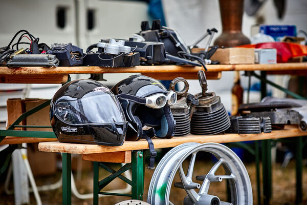 Bild: Zwischen zwei Motorradhelmen – Integral und offener Jet mit Sturmbrille – warten luftgekühlte Zylinder und eine Leichtmetallfelge auf dem Veterama-Teilemarkt auf neue Besitzer