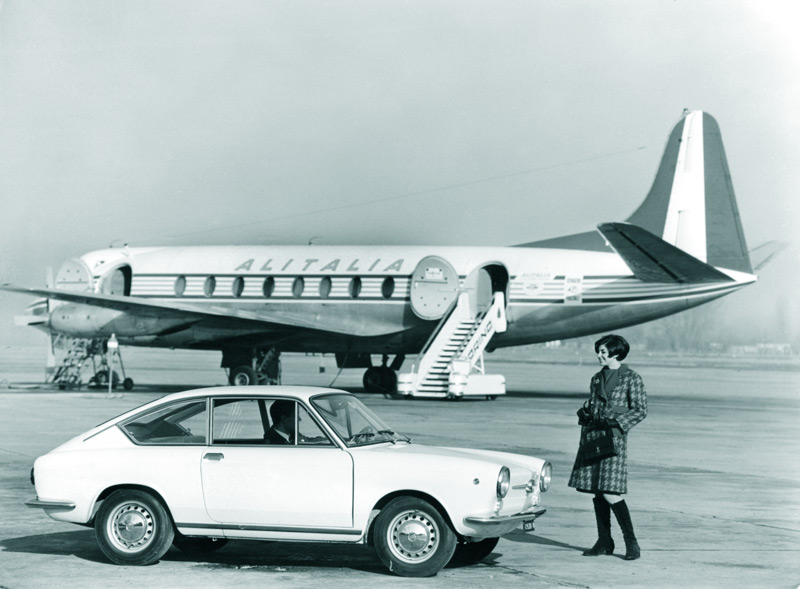 Fiat 850 Coupé von 1967 vor einer Alitalia-Maschine