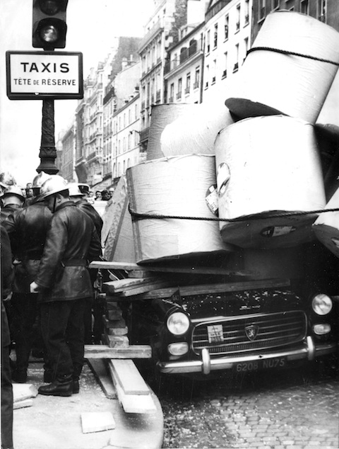 Peugeot 404 wird in Papier unter Papierrollen begraben (1965)