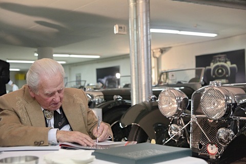 Norman Dewis beim Signieren des Jaguar-Buchs