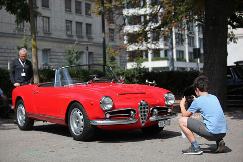Mit dem Handy vor dem Alfa Romeo Giulia Spider Veloce